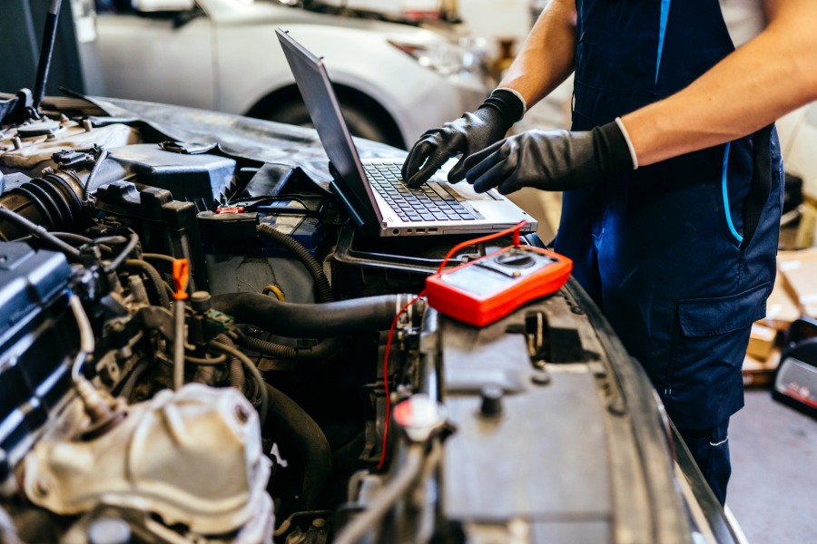 Auto repair shop service bay with a vehicle being worked on by technicians