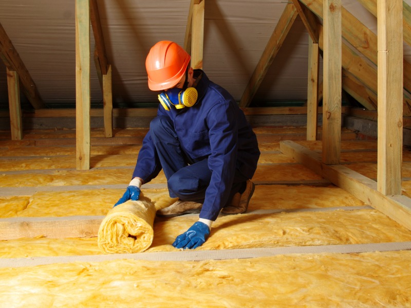 Home services contractor installing attic insulation in a residential attic